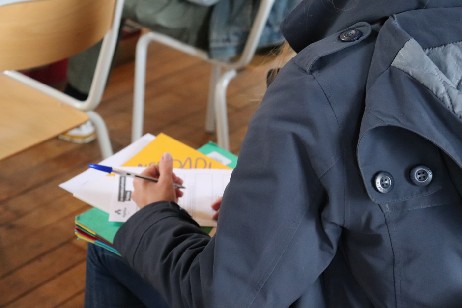 Une étudiante prend des notes sur le livret distribué par la formatrice