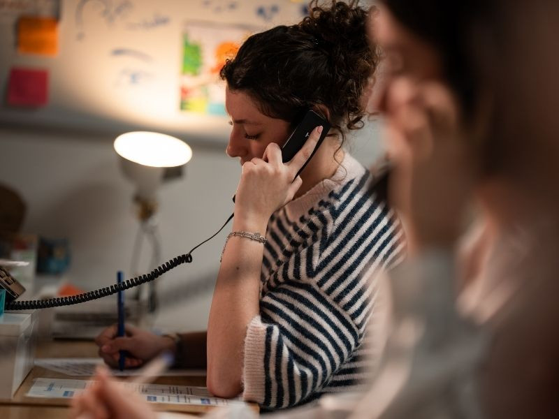 Jeune femme répondant à un appel dans un service d’écoute, illustrant l’accompagnement en santé mentale des étudiants