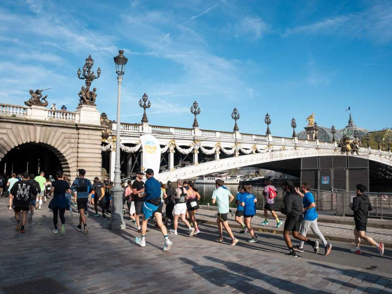 Coureurs participant à un marathon sur un pont à Paris, illustrant la préparation et le défi physique avant une échéance importante