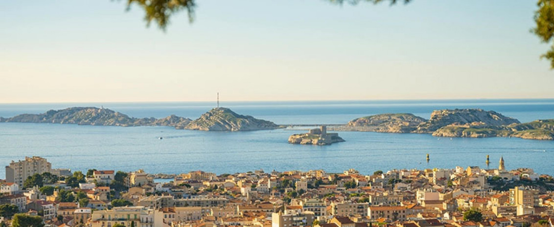 Photographie de la vue panoramique de Marseille, avec les maisons au premier plan et la mer en arrière-plan.
