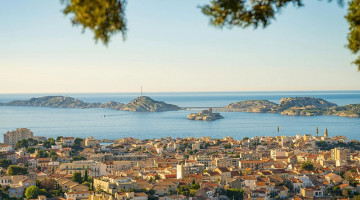 Photographie de la vue panoramique de Marseille, avec les maisons au premier plan et la mer en arrière-plan.